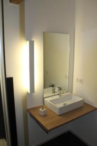 een badkamer met een witte wastafel en een spiegel bij Appartements Bad Birnbach in Bad Birnbach