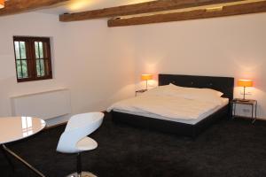 sypialnia z łóżkiem oraz 2 stołami i krzesłami w obiekcie Appartements Bad Birnbach w mieście Bad Birnbach