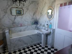 a bathroom with a bath tub and a sink at The Law House in Coldingham