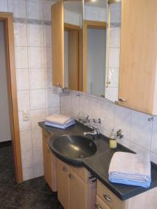 a bathroom with a sink and a mirror at Ferienwohnungen - An der Kunstakademie in Heimbach