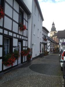 eine Kopfsteinpflasterstraße in einer Stadt mit weißen und schwarzen Gebäuden in der Unterkunft Ferienwohnungen - An der Kunstakademie in Heimbach