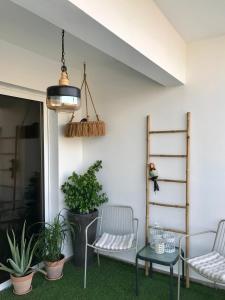 eine Terrasse mit 2 Stühlen, einem Tisch und Pflanzen in der Unterkunft Fat Cow Apartment 101 in Larnaka