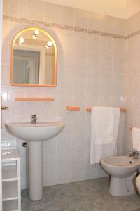 a bathroom with a sink and a toilet and a mirror at Residenza Mediterranea in Villasimius