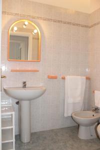 y baño con lavabo, aseo y espejo. en Residenza Mediterranea, en Villasimius