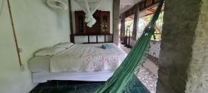 a bed in a room with a hammock at Pousada Bodega da Terra in Pirangi do Norte