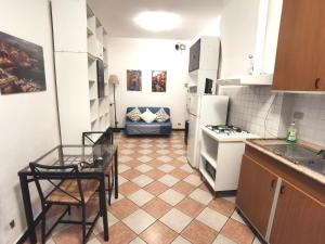 una cocina con electrodomésticos blancos, mesa y sillas en Residence La Lanterna, en Génova