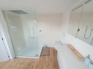 a white bathroom with a shower and a tub at Spacious Loft in the Historical Centre in Ghent