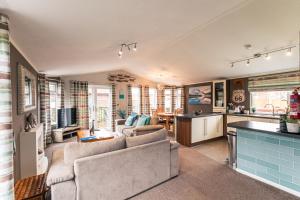 a living room with two couches and a kitchen at Kingfisher Lodge with Hot Tub in Malton