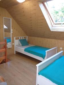 a bedroom with two beds in a wooden cabin at Szafir in Kuźnica