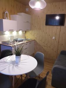 uma cozinha com uma mesa branca e cadeiras num quarto em Szafir em Kuźnica