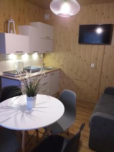 a kitchen with a white table and chairs in a room at Szafir in Kuźnica