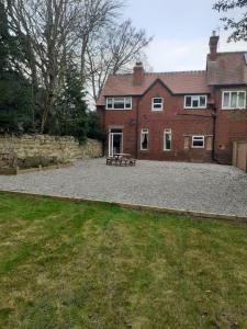 a large brick house with a bench in front of it at West Garth Cottage in Malton