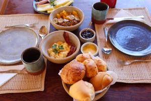 een tafel met borden en schalen van voedsel bij Pousada Iansã in Ponta do Anel