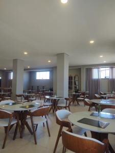 an empty restaurant with tables and chairs at Hotel Quartzo in Cristalina