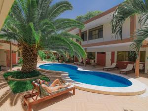 a woman laying in a chair next to a pool at El Angolo Piura in Piura