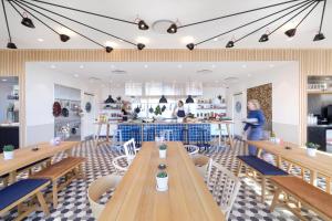 a restaurant with wooden tables and chairs and a counter at Zoku Copenhagen in Copenhagen +37 photos