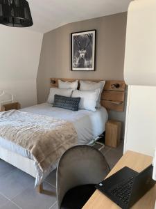 1 dormitorio con cama y escritorio con ordenador portátil en LES MYRTILLES Aix les Bains, en Aix-les-Bains