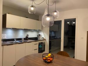 una cocina con una mesa con un bol de fruta. en LES MYRTILLES Aix les Bains, en Aix-les-Bains