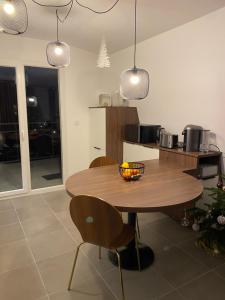 una cocina con una mesa de madera con sillas y luces colgantes en LES MYRTILLES Aix les Bains, en Aix-les-Bains