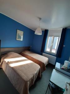 a blue room with two beds and a window at hotel Melissa in Péruwelz