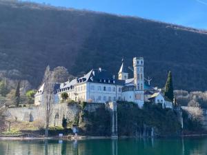 un castillo en una isla en un cuerpo de agua en LES MYRTILLES Aix les Bains, en Aix-les-Bains