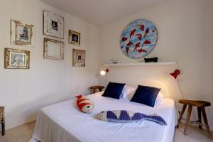 a bedroom with a white bed with a stuffed animal on it at Le Bastidon de PAMPELONNE in Saint-Tropez