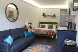 a living room with a couch and a bed at Boutique Stylish Self Contained Studio Shropshire in Pattingham
