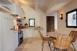 eine Küche mit Tisch und Stühlen in einem Zimmer in der Unterkunft Le Bastidon de PAMPELONNE in Saint-Tropez