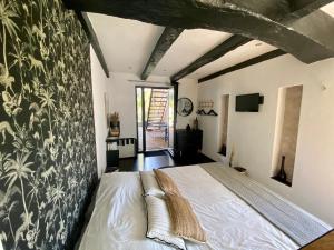 een slaapkamer met een groot bed in een kamer bij Ô Chambres d'Hôtes in Le Gua