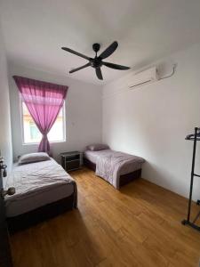 um quarto com 2 camas e uma ventoinha de tecto em LMS homestay em Alor Setar