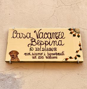 un signe sur un mur avec un chien sur le mur dans l'établissement Casa Vacanze Beppina Cortona, à Cortone