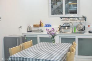 a kitchen with a table with a vase of flowers on it at Nhà của Sóc in Da Lat