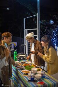 a group of people standing around a table with food at Nhà của Sóc in Da Lat +34 photos