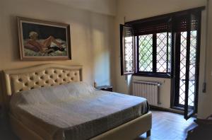 a bedroom with a bed and a painting on the wall at La Tana di Sofia in Rome