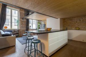 a kitchen with a counter and stools in a room at Duplex le Vorace in Lyon