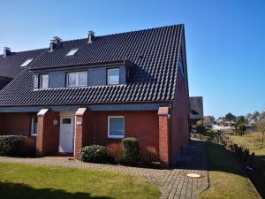 a red brick house with a black roof at Strandnah in Wenningstedt in Wenningstedt