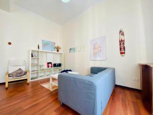 Castelnuovo Rooms في باليرمو: غرفة معيشة مع أريكة زرقاء وطاولة