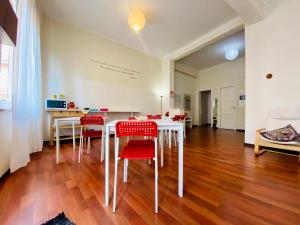 a dining room with a white table and red chairs at Castelnuovo Rooms in Palermo