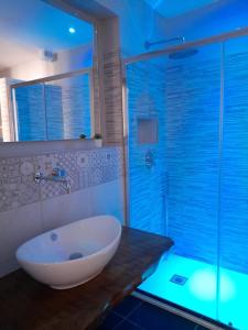 La salle de bains est pourvue d'une grande baignoire et d'une douche en verre. dans l'établissement Dimora Palma, à Alberobello