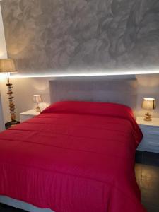 un letto rosso in una camera da letto con due lampade di Dimora Palma ad Alberobello