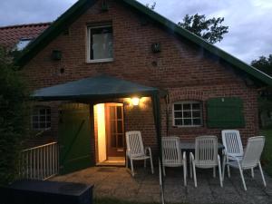 un patio con sillas y una mesa frente a una casa de ladrillo en Ferienwohnung im Teutoburger Wald / Münsterland - Versmold - Gütersloh -Bielefeld - Münster, en Versmold
