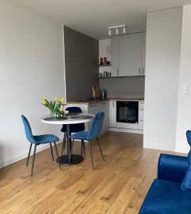 a kitchen and dining room with a table and chairs at Apartament Wiczlino in Gdynia