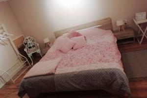 una camera da letto con letto e lenzuola e cuscini rosa di ländlich & gemütlich in Raeren mit 2 Schlafzimmern a Raeren
