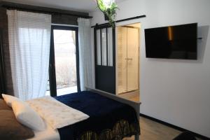 a bedroom with a bed and a flat screen tv at Apartament dla pary Stara Szkoła in Weremowice