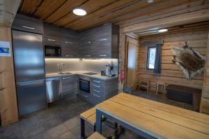 a kitchen with wooden walls and a table in a room at Villa Ankkuri in Savonranta