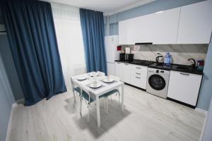 a kitchen with a white table and a washing machine at Нурсая#2 in Atyrau