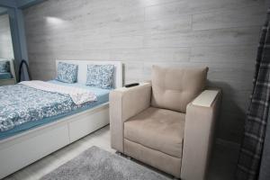 1 dormitorio con 1 cama y 1 silla en Нурсая#2, en Atyraū