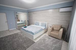 a small bedroom with a bed and a chair at Нурсая#2 in Atyraū