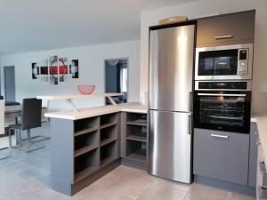 a kitchen with a stainless steel refrigerator and appliances at Les Villas Dorées - Villa Soleil face au Mont Ventoux in Plaisians