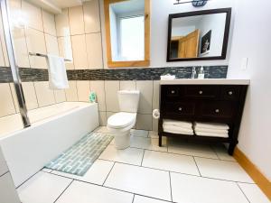 a bathroom with a tub and a toilet and a sink at Journey's End - 2 bed 1 bath Suite in Golden